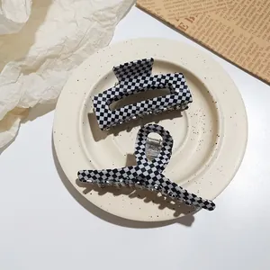 Detail of checkered acetate hair claw clips set including rectangular and cross design