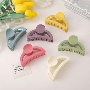 Close-up of matte semi-circular hair claws in various pastel colors and rounded teeth