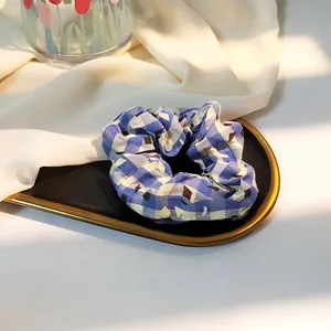 Blue and white plaid scrunchie with geometric patterns on a decorative tray