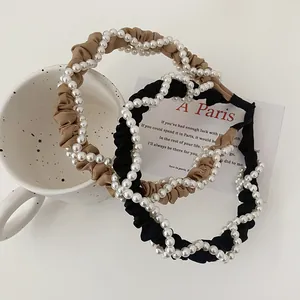 Detail of elegant pleated headbands with pearls in black and khaki vintage style
