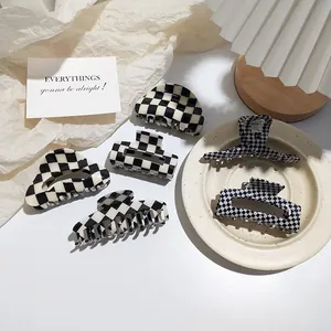 Detail view of large checkerboard hair claw clips in various geometric acetate shapes