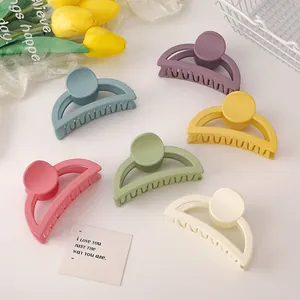 Flat lay of six matte pastel shark hair clips arranged with decorative tulips and card