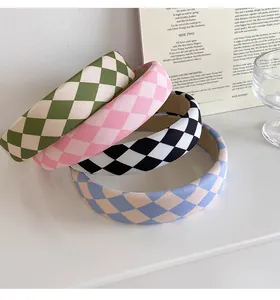 Close-up of thick checkered headbands in green, pink, black and light blue fabric