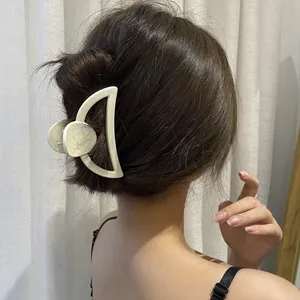 Sweet cream colored large hair claw clip for women shown in a back view hairstyle
