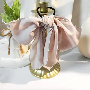 Detail der rosa Chiffon-Schleife mit feinen Nähten und elastischem Haargummi