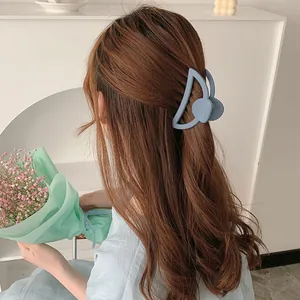 Morandi blue matte hair claw clip with geometric hollow design on a female model