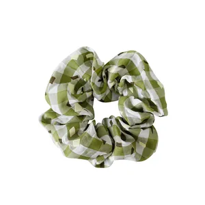 Sweet green and white plaid fabric scrunchie with brown polka dots on white background