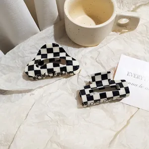 Detail of large acetate checkerboard hair claws in geometric triangle and trapezoid shapes
