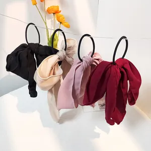 Detailansicht von vier farbigen Chiffon-Haargummis mit Schleifen an einem Display