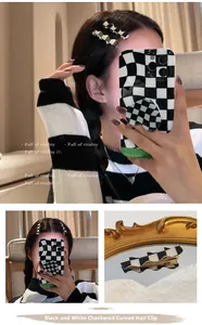 Close-up of black and white checkered acrylic wavy hair clips on a reflective surface