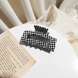 Large black and white checkered acetate hair claw clip for elegant summer hair styling