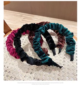Primer plano de diademas de terciopelo plisado en colores granate, negro, café y verde