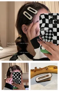 Detail view of cream acrylic hair clip with black border on a model's side hair