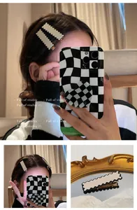 Macro detail of cream wavy hair clip with black border and metal duckbill attachment