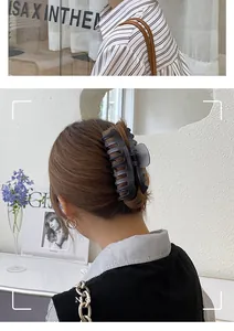 Detalle de una pinza para el pelo grande en negro mate sujetando un moño de estilo francés