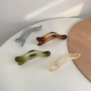 Dettagli di quattro fermagli per capelli opachi in vari colori su uno sfondo minimale
