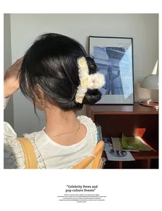 Dettaglio della pinza per capelli in peluche bianca con ricami di orsetti gialli