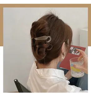 Close-up of elegant matte barrette hair clips in chocolate and beige on long wavy hair