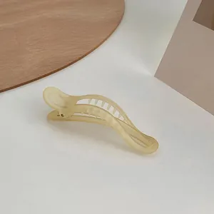 Dettaglio del fermaglio a banana giallo opaco con struttura interna a denti fini