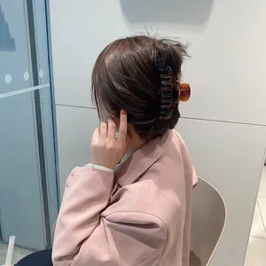 Pinza para el pelo grande de color ámbar mate para cabello grueso vista de perfil en modelo