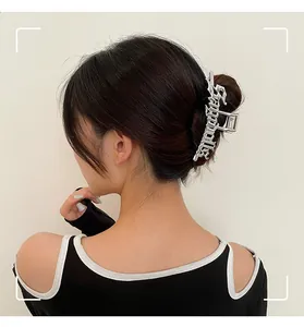 Pinza para el pelo plateada con letras góticas en un elegante peinado recogido