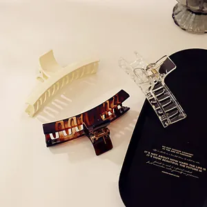 Three-piece hair claw clip set in ivory, tortoiseshell, and transparent resin finishes
