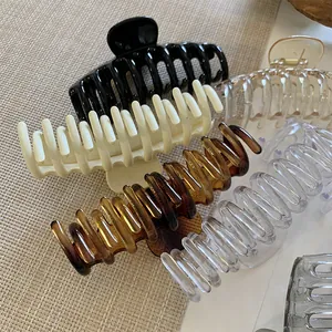 Vista detallada de pinzas para el cabello grandes, mate y transparentes en varios colores neutros