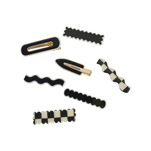 Set of seven black and white checkerboard acrylic hair clips in various geometric shapes
