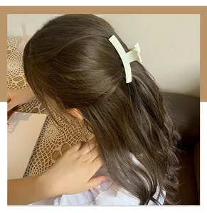 Matte cream long hair claw clip styling elegant half-up hairstyle on brunette hair