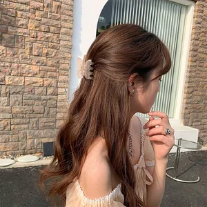 Primer plano de pinza para el pelo con forma de mariposa rosa translúcida en uso