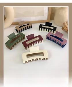Detailed view of large matte acrylic hair claws in multiple two-tone color combinations