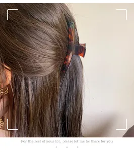 Elegant tortoiseshell claw clip for women's long hair shown in a half-up hairstyle