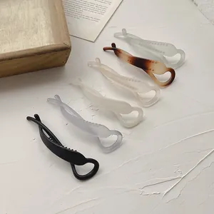 Close-up of minimalist matte banana hair clips in six assorted Morandi colors