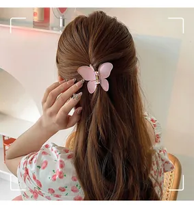 Detalle de pinza para el pelo de mariposa rosa mate usada en el peinado de la modelo