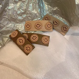 Close-up of four vintage PU leather hair clips with embroidered smiley face patterns