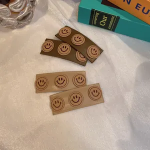 Detailed macro view of French vintage PU leather hair clips with cute smiley face patches