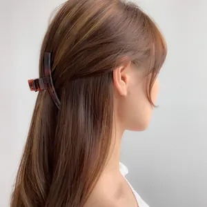Detail of dark brown tortoiseshell hair claw clip used in a semi-tied hairstyle