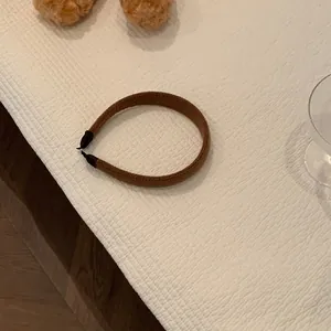 Detailed knit texture of a brown winter headband with protective black rubber tips