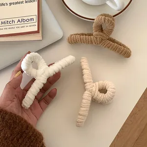 Three plush hair claws in ivory, yellow, and brown with striped velvet texture for women