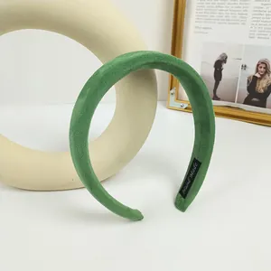 Detalle de la diadema de terciopelo verde con etiqueta 'Hand Made' y textura suave