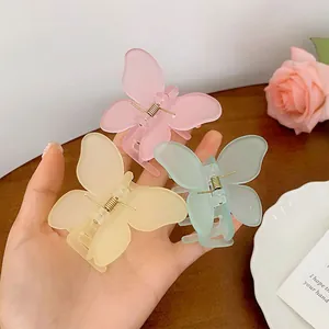 Primer plano detallado de pinzas para el cabello de mariposa traslúcidas en rosa, amarillo y verde