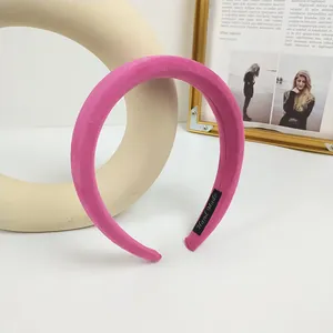 Detalle de la diadema de terciopelo rosa que muestra la etiqueta de tela hecha a mano