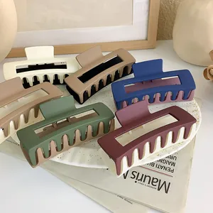 Detailed view of matte square hair claws in five dual-tone colors on a ceramic tray