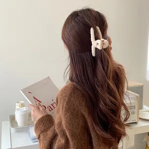 Creamy white plush bow claw clip for women, elegant faux fur hair accessory for buns