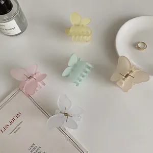 Detalle de pinzas para el cabello de mariposa en acrílico mate en cinco colores pastel