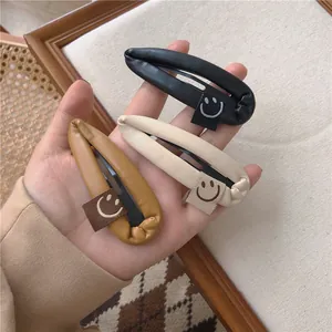 Detailed view of three PU leather teardrop hair clips with smiley face embroidery