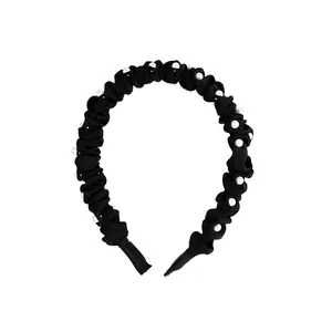 Serre-tête élégant en tissu plissé noir avec perles blanches et design à nœud central
