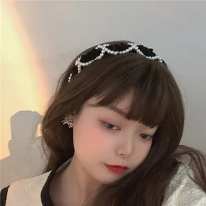 Detail of velvet pearl headband and bow earrings set on model with soft lighting