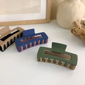 Detailed macro view of matte two-tone rectangular hair claws with double-layered teeth