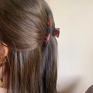 Elegant amber tortoise shell hair claw clip for women shown in a half-up hairstyle
